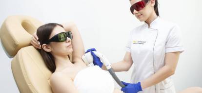 Kosmetolog przeprowadza zabieg depilacji laserowej pach.