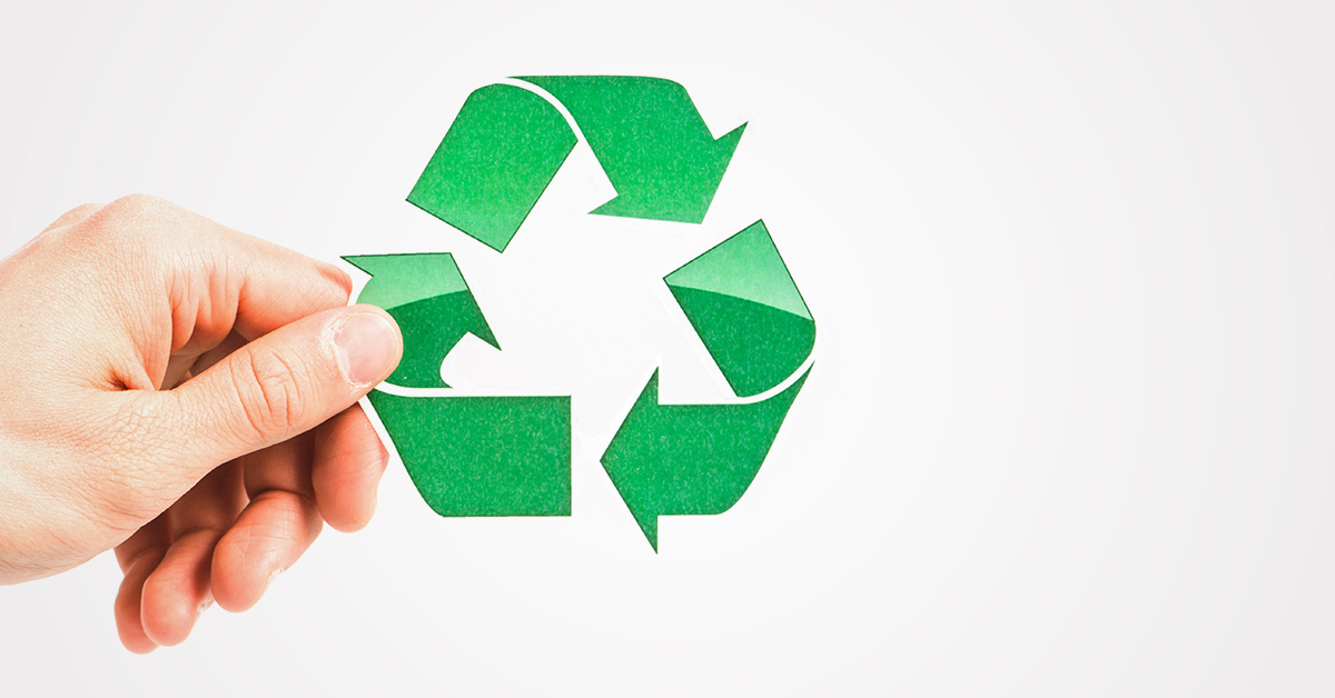 Dłoń trzymająca znak recyclingu.